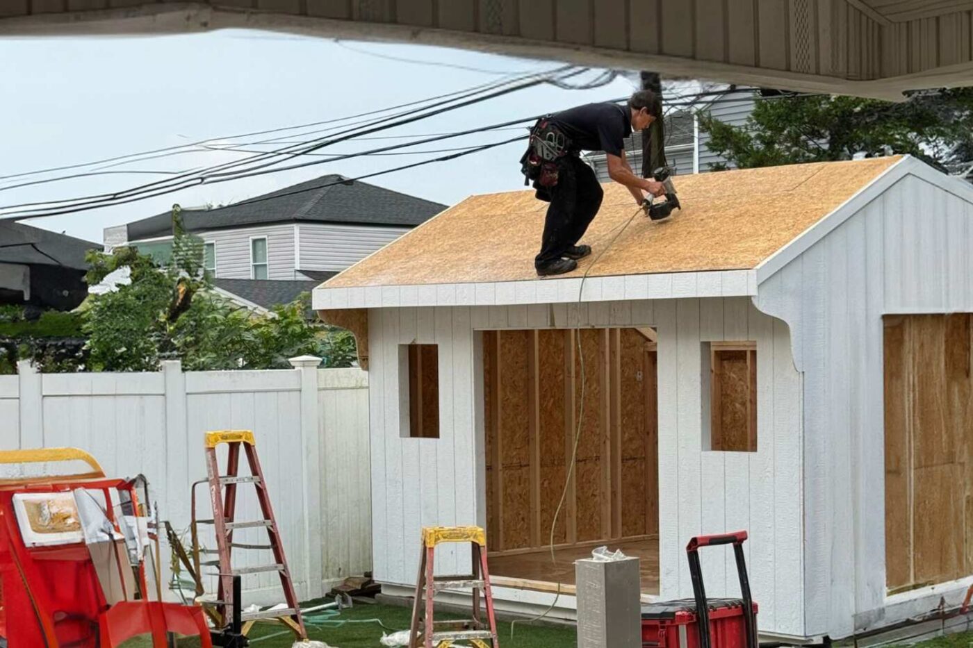 View of shed delivery on a rainy day in NY with white saltbox style shed